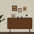 Wooden Console Table With Drawers Golden Handles And Green Plant Near Wall Art