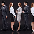 Group of Business Professionals in Formal Attire Standing with Documents and Coffee