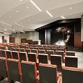 Large Modern Conference Room With Rows of Seats Presentation Screen and Ceiling Lighting