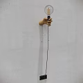 Hand Shaped Wooden Wall Lamp With Transparent Glass Bulb And Filament On White Wall