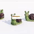 Cute Snail Sculptures With Green Body Dark Brown Shell And Adorable Smiling Face