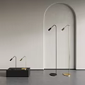 Three Black And Gold Floor Lamps Against Gray Wall With Arched Doorway And Floor