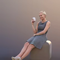 Smiling Woman In Gray Sleeveless Dress Holding White Cup Sitting On Chair