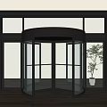 Modern Revolving Glass Door Entrance With Black Frame And Indoor Plant