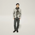 Handsome Man Dressed in Gray Jacket and Black Pants Standing Against Gray Background With Scarf