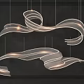 Modern Flowing Ribbon Chandelier With Soft Glowing Light On Dark Background