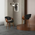 Modern Black Leather Dining Chairs With Wooden Legs Against Grey Walls And Artwork