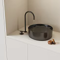 Modern Black Bathroom Sink With Dripping Faucet On White Countertop And Soap Bars