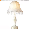 White Table Lamp with Decorative Pattern on Base and Elegant Lace Lampshade Adorned with Fringes