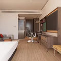 Modern Hotel Guest Room With Large Bed Sofa Desk Chair TV And Wooden Flooring