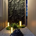 Outdoor Lights Illuminating Garden Pathway With Stone Wall Wooden Slats Greenery And Decorative Rock
