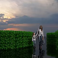 Path Between Lush Green Bushes With Mother And Child Walking Under Sunset Sky Reflections
