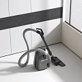 Sleek Gray Vacuum Cleaner With Flexible Hose And Nozzle For Efficient Home Cleaning