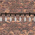 Industrial Rustic Chandelier With Black Pipe Frame And Glass Bottles On Brick Wall