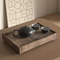 Black Teapot And Matching Cups In Wooden Tray On Wooden Table With Geometric Wall Art
