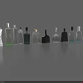 Various Colored Wine Bottles and Glasses with Different Shapes Arranged on Gray Surface