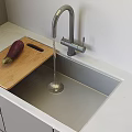 Modern Kitchen Faucet Over Sink With Wooden Cutting Board Eggplant Light Countertop And Gray Cabinets