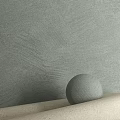 Gray Textured Sphere Component On Light Surface Against Light Green Wall