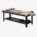 Massage Bed with Black Frame Gray Beige Blanket Pillows and Lower Shelf Stacked Towels