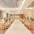 Elegant Banquet Hall With Chandeliers Floral Carpet Long White Aisle Decorated Tables And Large Windows