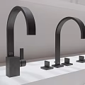 Various Modern Faucet Models With Large Black Faucet Displayed On White Countertop In Showroom