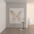 Light Toned Butterfly Painting Hanging On Wall With Light Wall Background And Small Table Plant