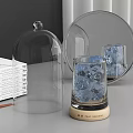Perfume Cosmetics Display Featuring Transparent Glass Cloche Blue Ice Cubes Wooden Base and Open Book