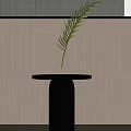 Black Round Top Side Table With Cylindrical Base Green Leaf Vase Against Light Wall 3d model