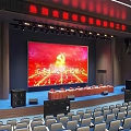 Large Conference Hall Interior With Stage Large Screen Party Emblem Red Background And Arranged Seats