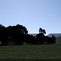 Modern Office Building Exterior With Glass Facade White Structure Front Entrance And Parked Cars
