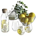 Elegant Decorative Ornament Set With Lemons Glass Bottle Cups Whisk And Green Foliage
