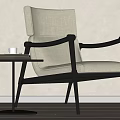 Modern Accent Chair With Black Frame Beige Upholstery And Side Table With White Cup Books