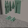 Set of Green Towels Hanging On Metal Hooks Against Beige Wall In Bathroom