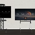 Two TVs Displaying BEYOND DUNE on Black Metal White Stands Against Light Wall Wooden Floor