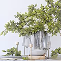 Stylish Tableware Set with Green Plants Wine Glasses Plates and Candle Holders on White Table