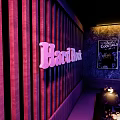 Hard Rock Bar Interior With Purple Lighting Music Neon Sign And Stage Seating Area