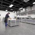 Commercial Catering Kitchen Interior With Chefs Working At Stainless Steel Worktables And Commercial Appliances