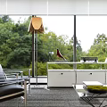 Modern Office Interior With White Bookshelves Red Chair Glass Desk Laptop And Green View