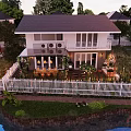 Lush Garden Landscape With Pergola Vines Wooden Deck And Outdoor Dining Setup