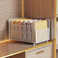 Wardrobe Interior With White Metal Mesh Storage Basket Holding Folded Fabrics On Wooden Countertop