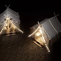 Cozy Canvas Tents Illuminated with String Lights on Gravel Ground at Night