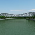 Modern Arch Bridge With Roadway And Railings Near Modern Buildings Trees And River