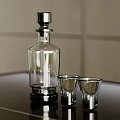 Small Glass Shot Glasses With Clear Glass Decanter On Black Countertop And Light Colored Wall