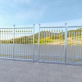 Sturdy Metal Fence With Golden Decorative Balls Against Green Hills Blue Sky And Gray Pavement