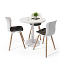 Round White Dining Table Set With Three Chairs Wooden Legs Black Cushions And Green Plant