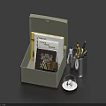 Open Gray Box With Notebook Colorful Pens Metal Pen Holder And Magnifying Glass