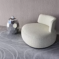 Cream Velvet Single Seater Sofa With Circular Design And Silver Geometric Vase On Gray Carpet