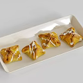 Delicious Four Puff Pastry Snacks With White Icing On White Rectangular Plate