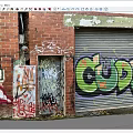 Red Brick Wall With Vibrant Graffiti Art And Colorful Designs On Roller Shutter Door