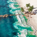 Tropical Waterfront Landscape With Sandy Beach Palm Trees Rocks And Clear Blue Waves